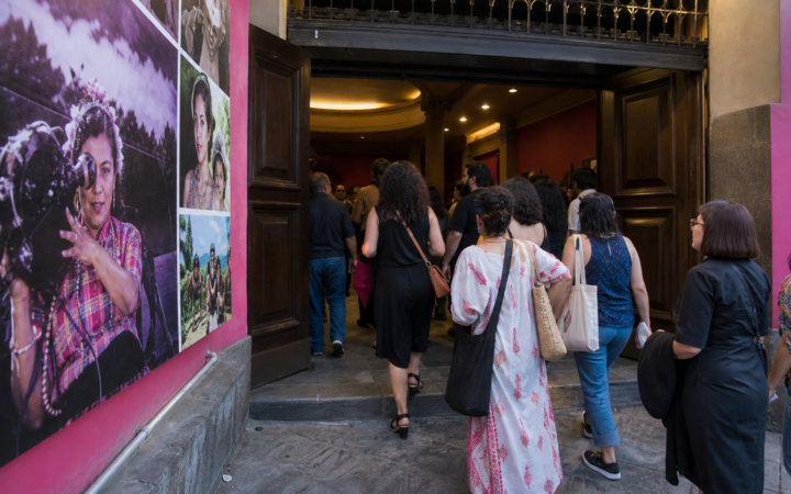 Público observa una proyección cinematográfica en una sala cultural durante una muestra dedicada a mujeres creadoras.