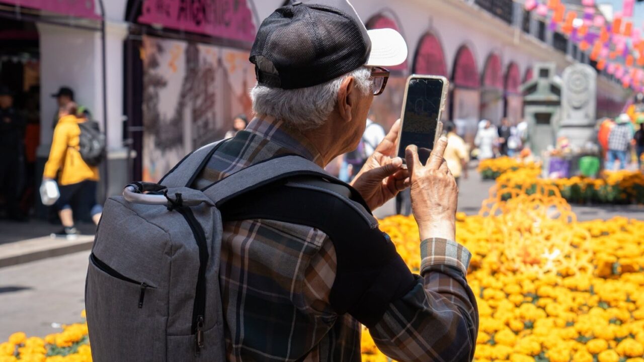 Un visitante fotografía una instalación de flores de cempasúchil en el centro de Toluca.