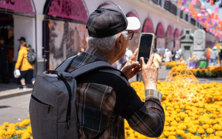 Un visitante fotografía una instalación de flores de cempasúchil en el centro de Toluca.