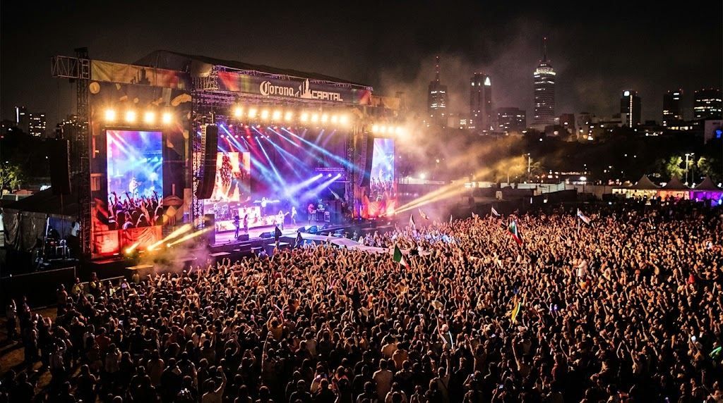 Escenario iluminado del Corona Capital y público durante un concierto nocturno.